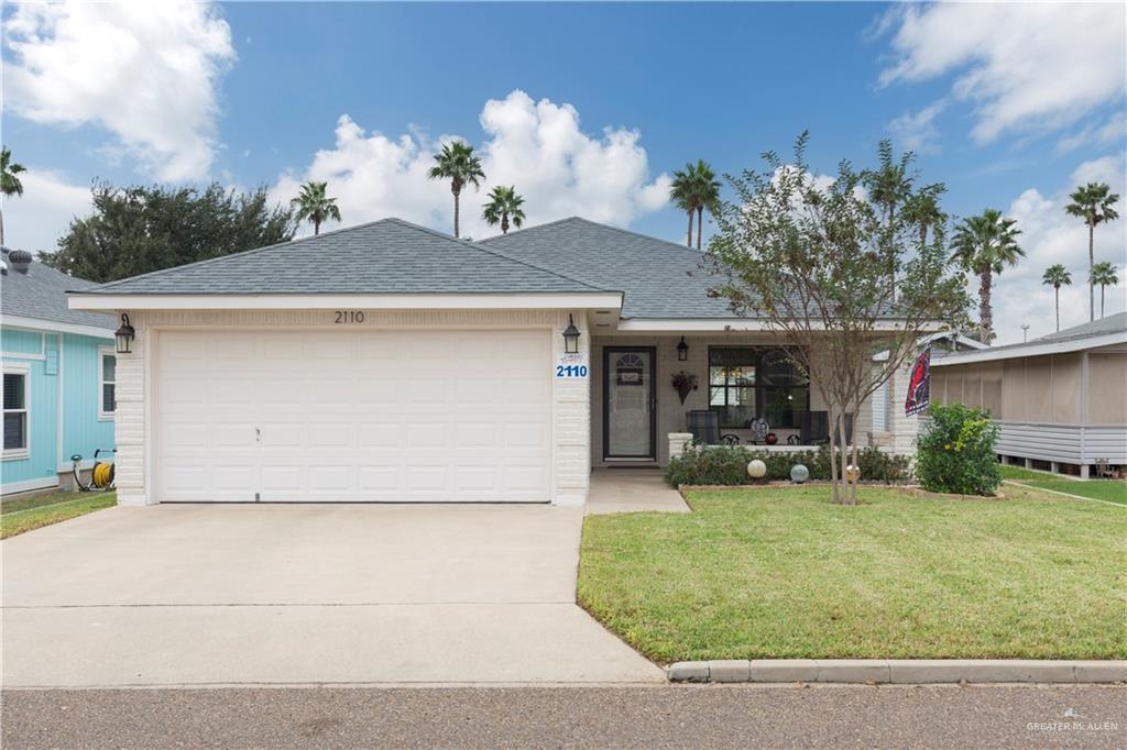 A charming brick home with a well-maintained front yard, featuring clean landscaping and mature trees.  This home is immaculate and well kept.  Pretty landscaping and a great front porch!