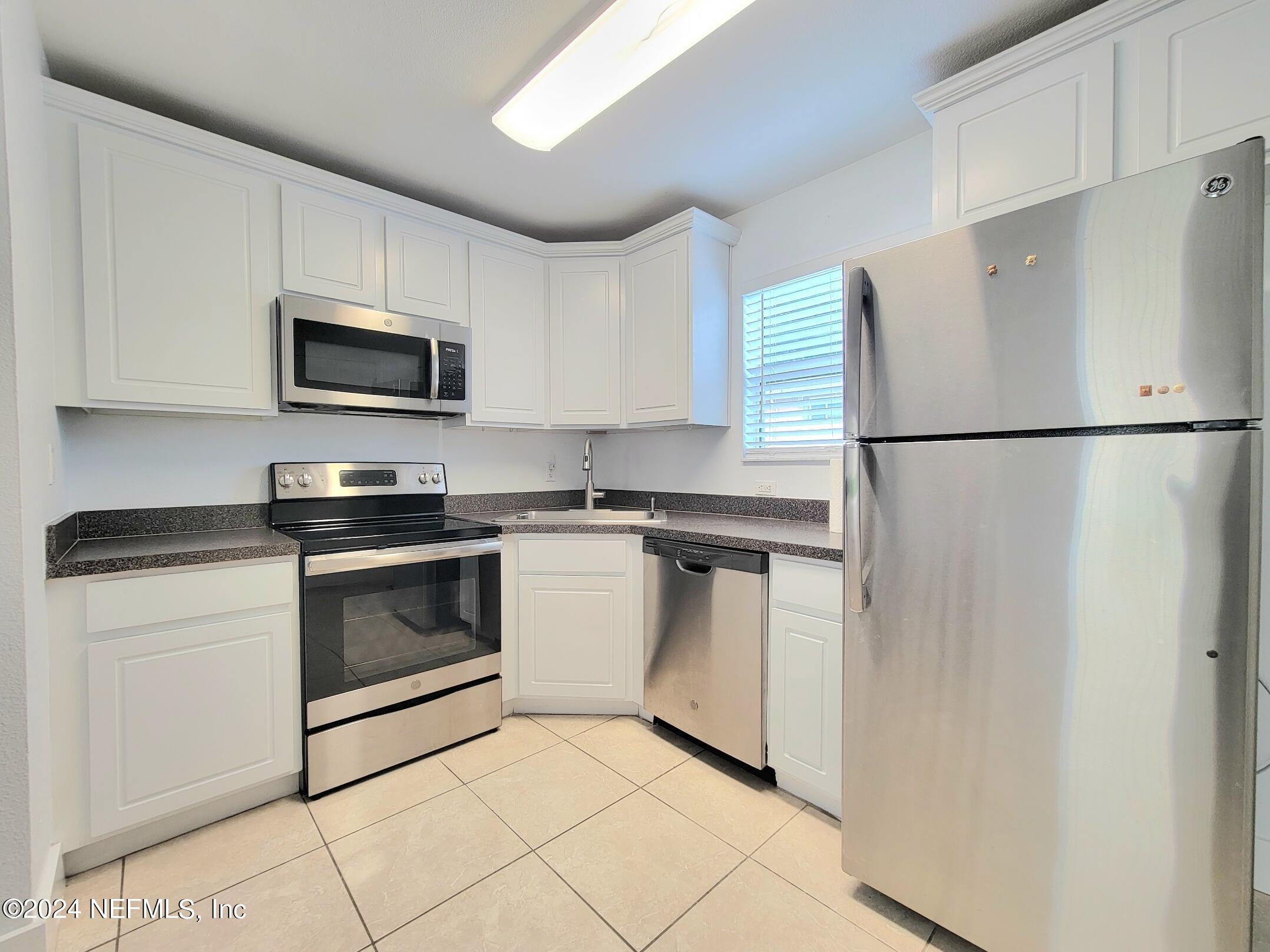 a kitchen with white cabinets and white stainless steel appliances