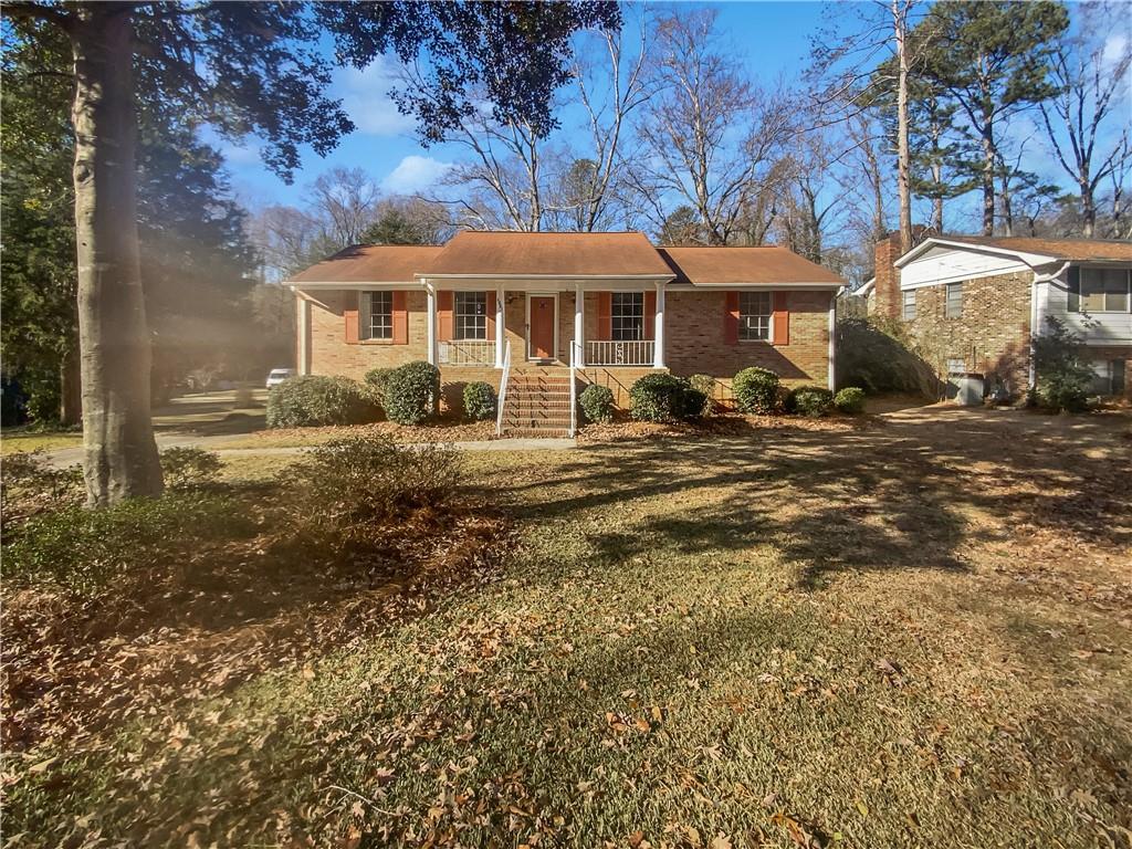 a front view of house with yard outdoor seating and covered with trees