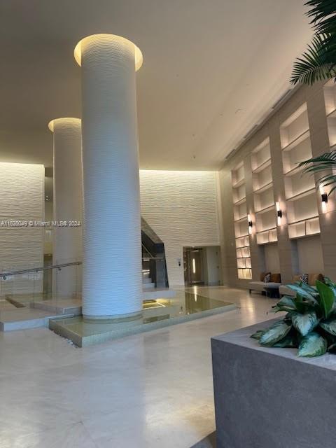 a lobby with furniture and potted plants