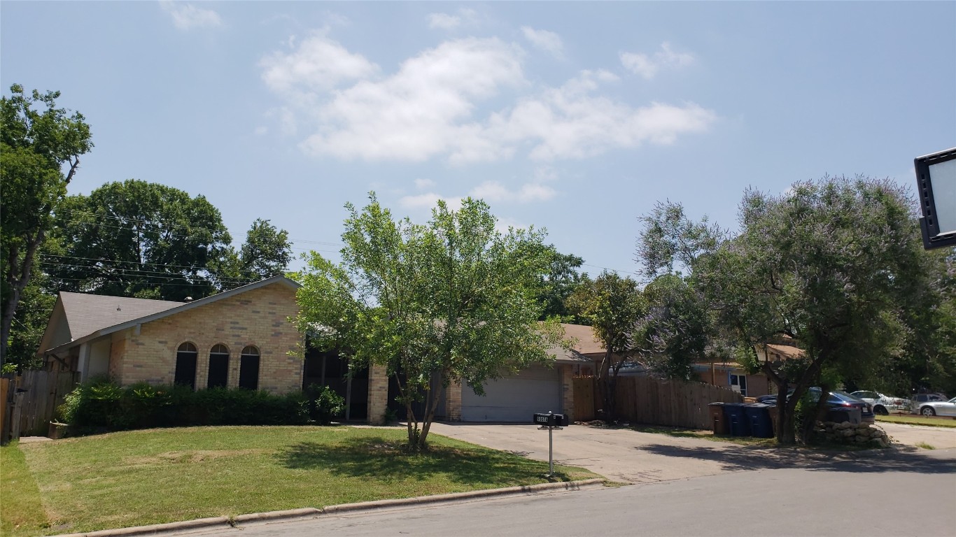 a front view of a house with a yard and trees