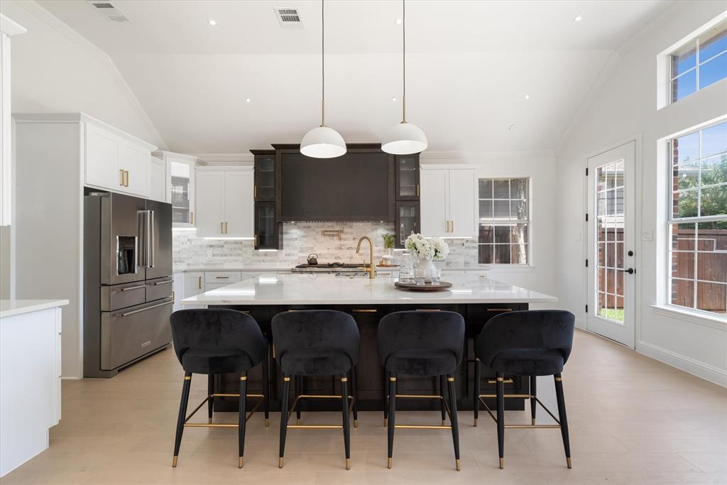 a kitchen with a dining table chairs and white cabinets