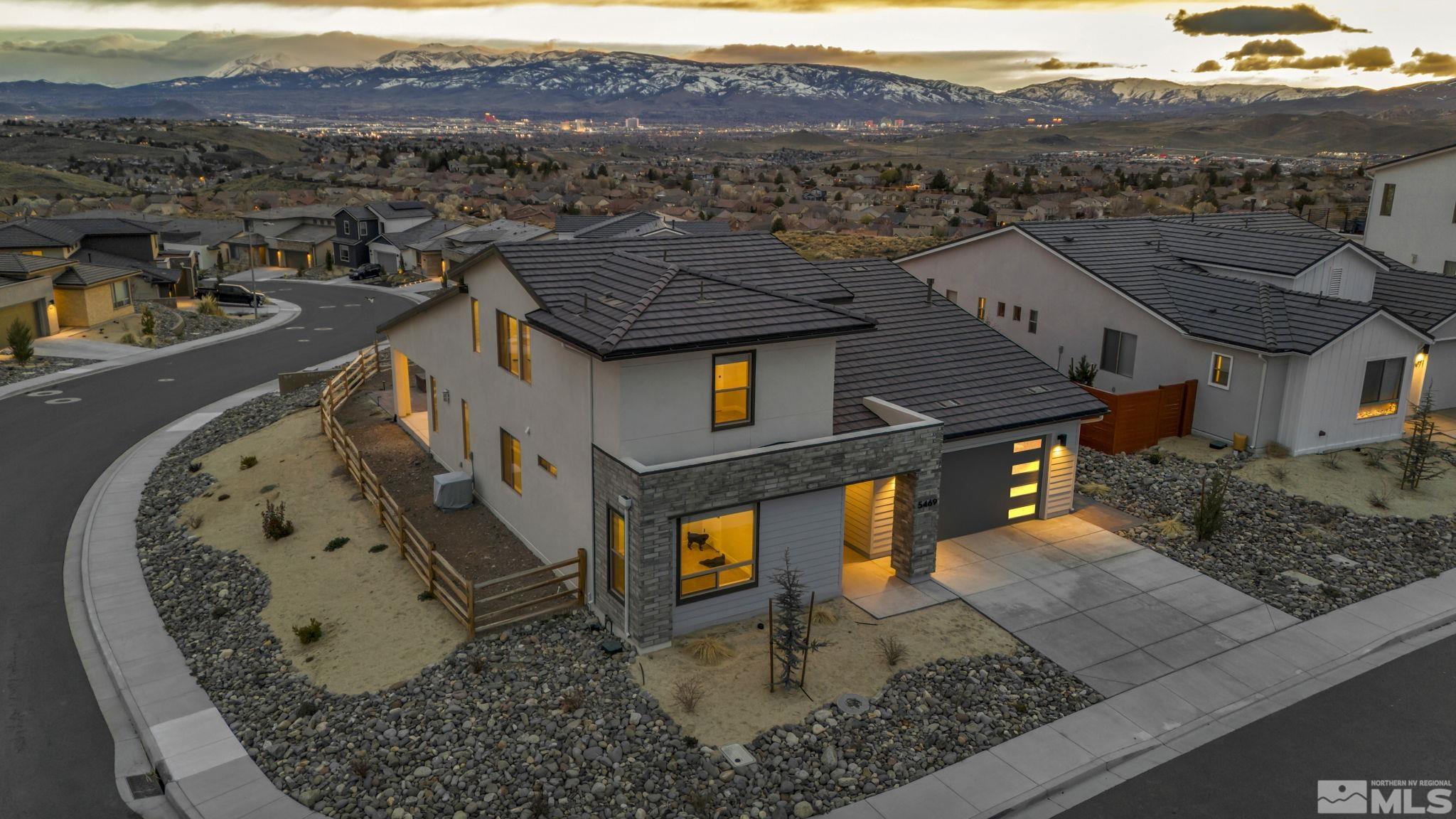 an aerial view of a house with a mountain