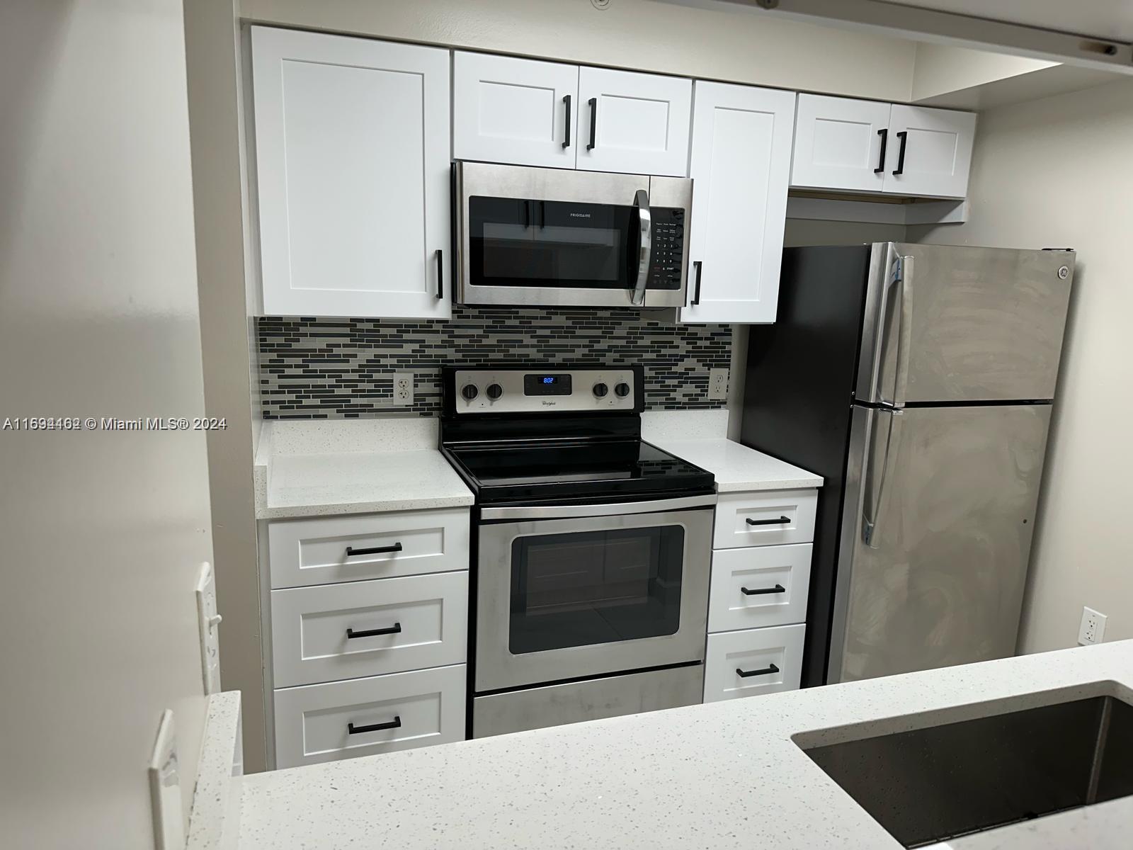 a kitchen with cabinets and steel stainless steel appliances