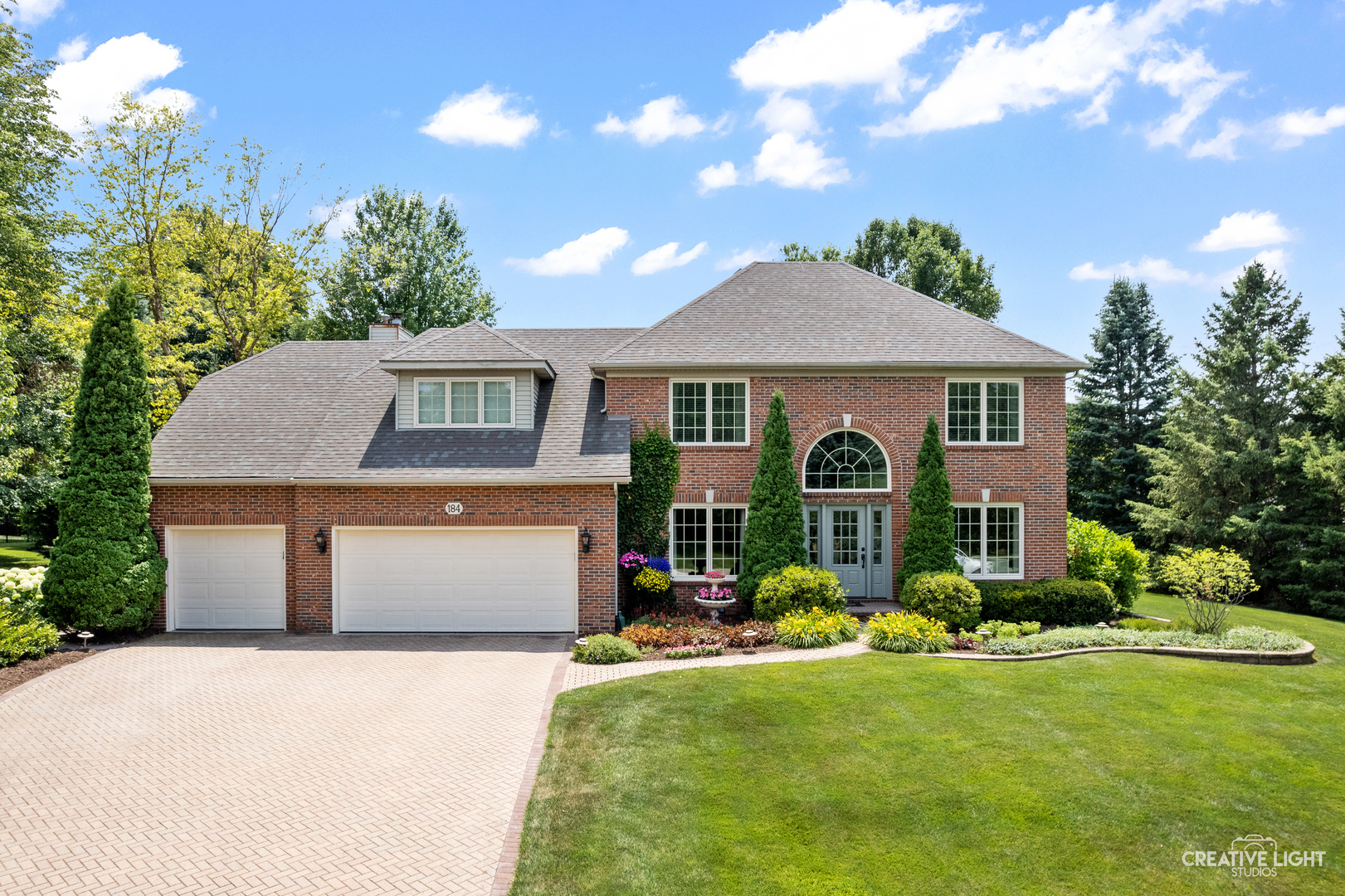 a front view of a house with yard and green space