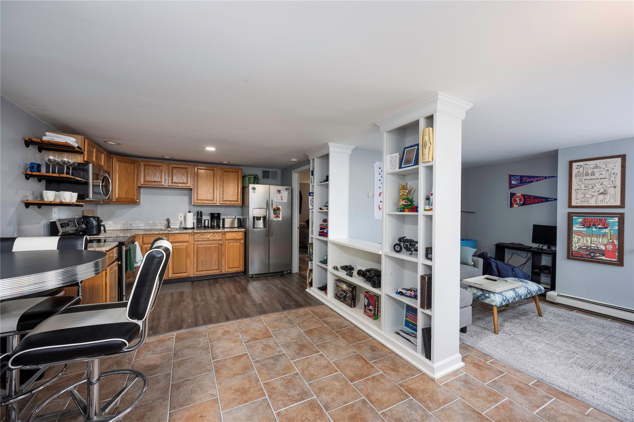 a view of kitchen with stainless steel appliances living room and chair