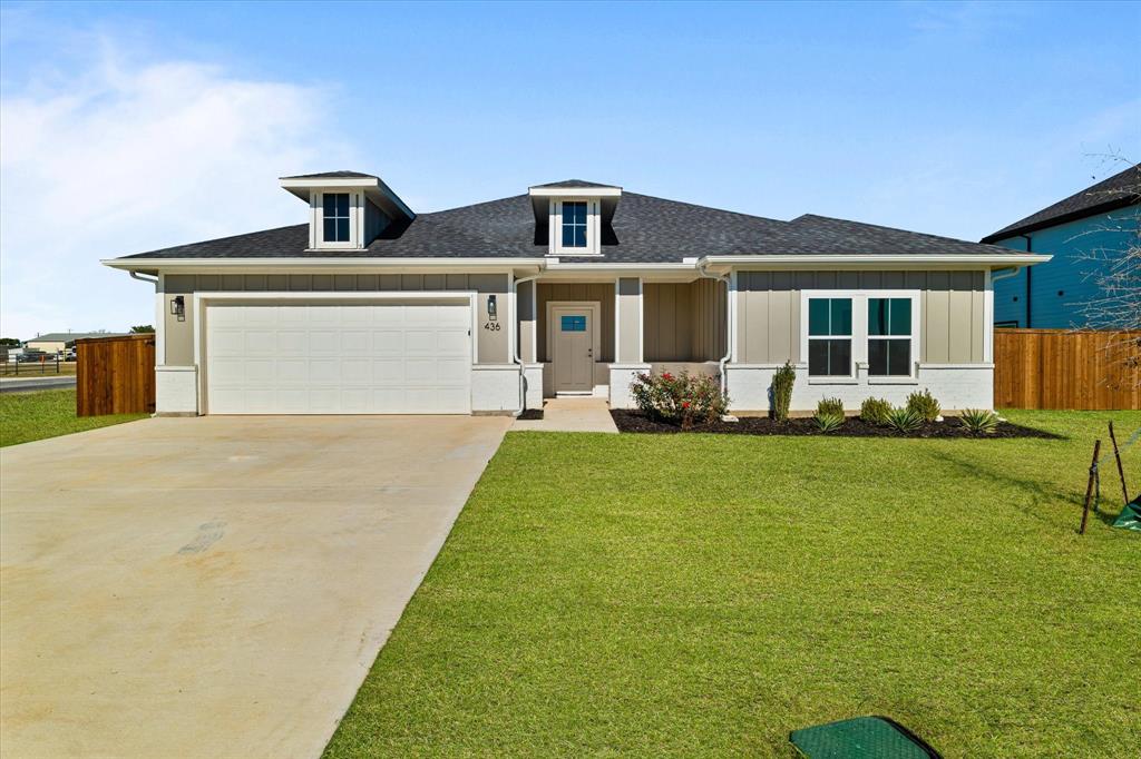 View of front of property with a garage and a front lawn