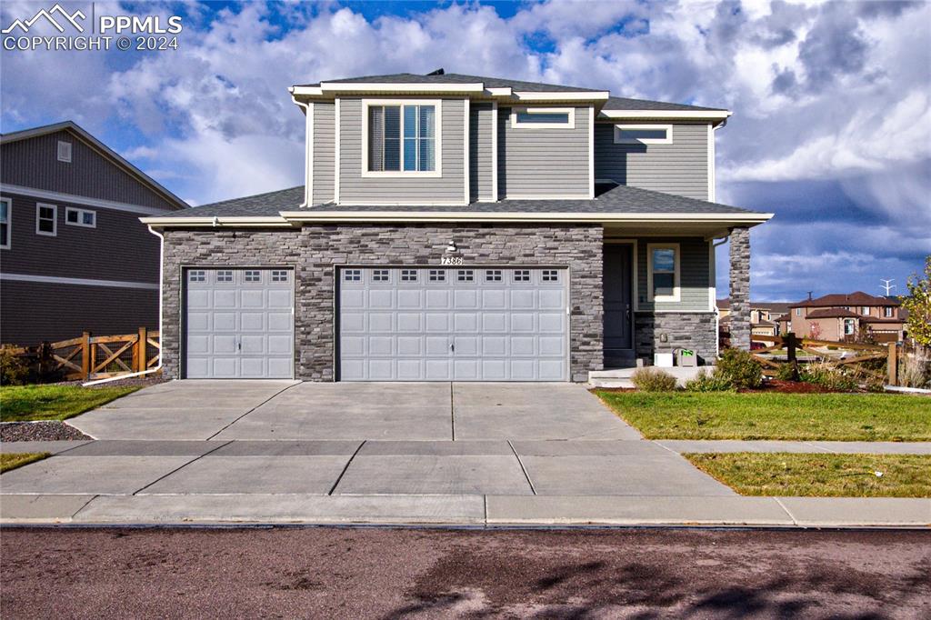 View of front of house with a front yard and a garage