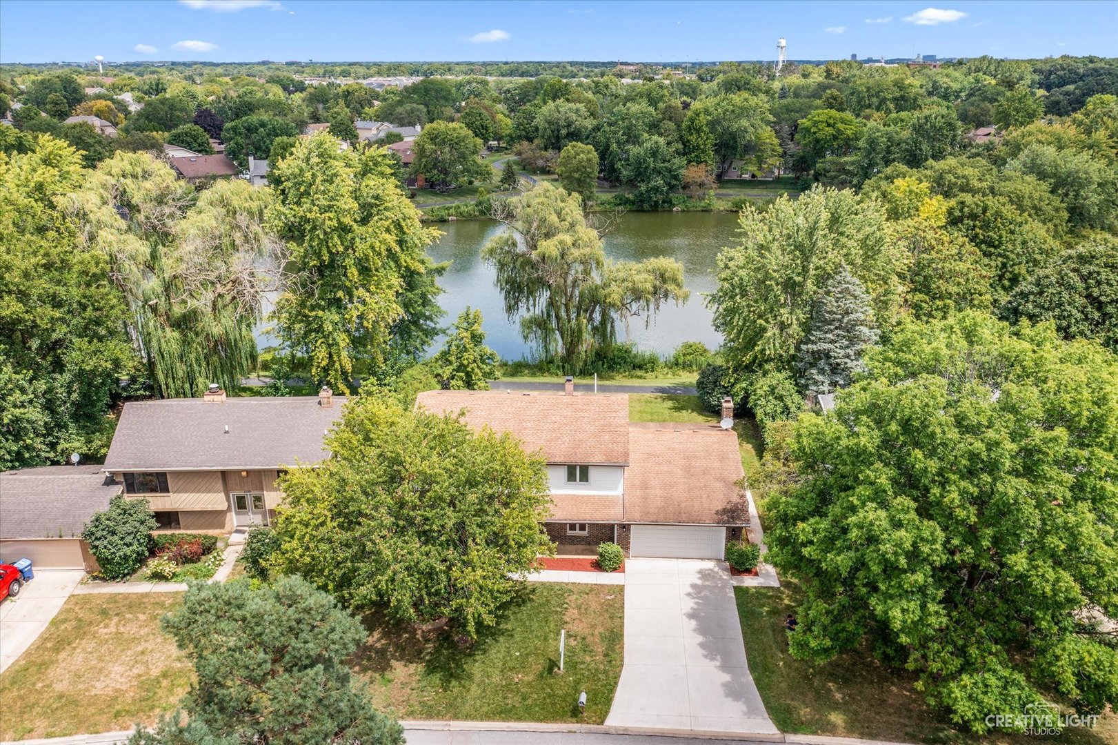 an aerial view of a house with a yard and lake view