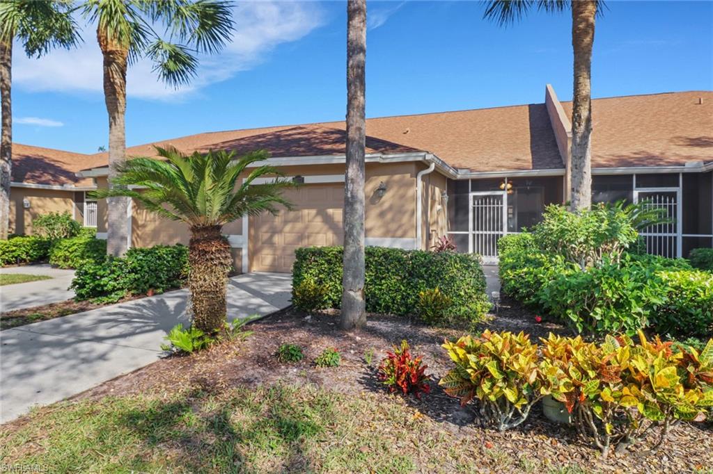 a front view of a house with a yard and potted plants