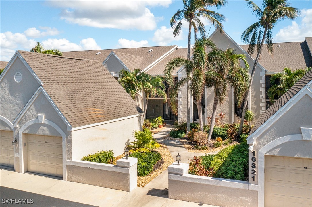 a view of a house with palm tree and wooden fence