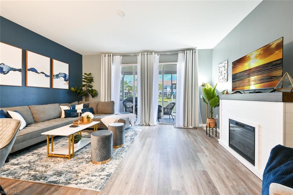 a living room with furniture a flat screen tv and a fireplace