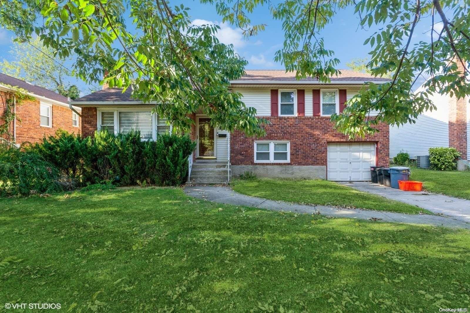 a front view of a house with a yard and trees