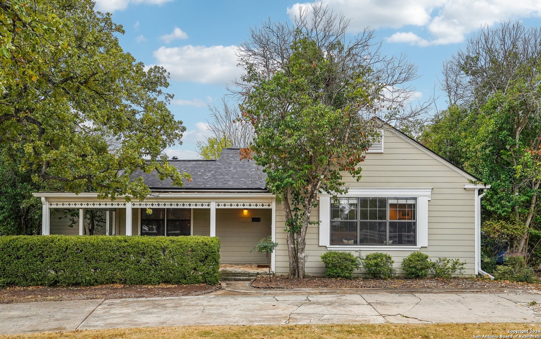 a front view of a house with a yard and potted plants