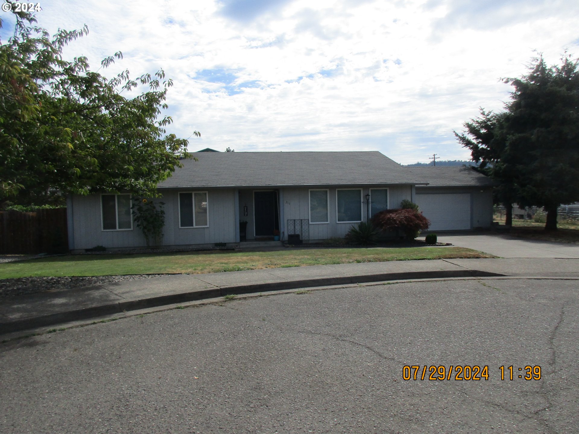 a front view of a house with a yard and trees