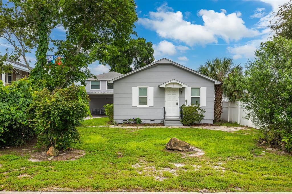 a front view of a house with a yard and trees