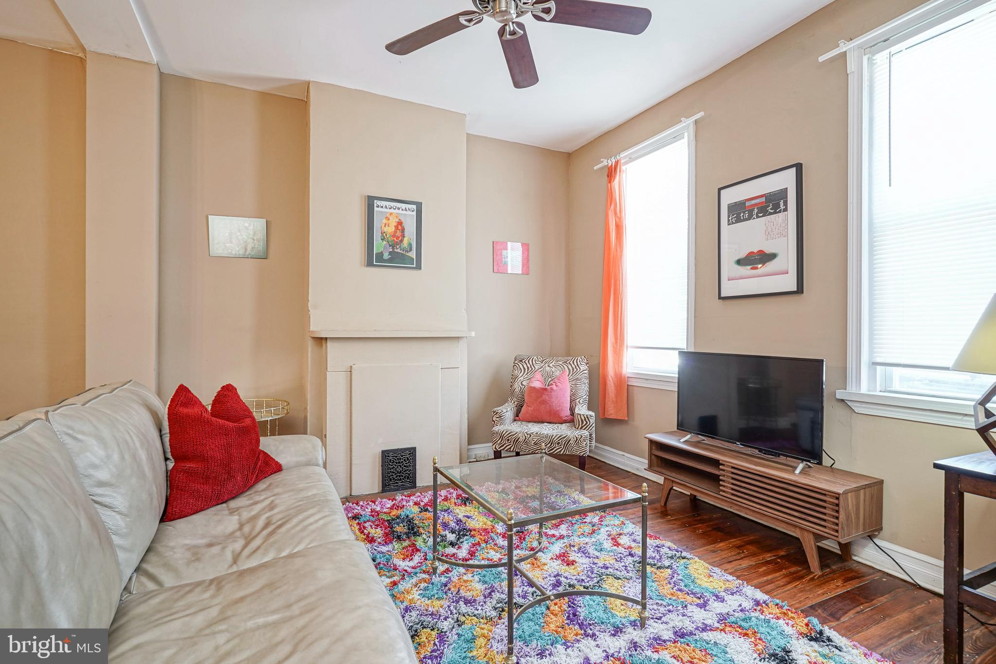 a living room with a couch bookshelf and a flat screen tv