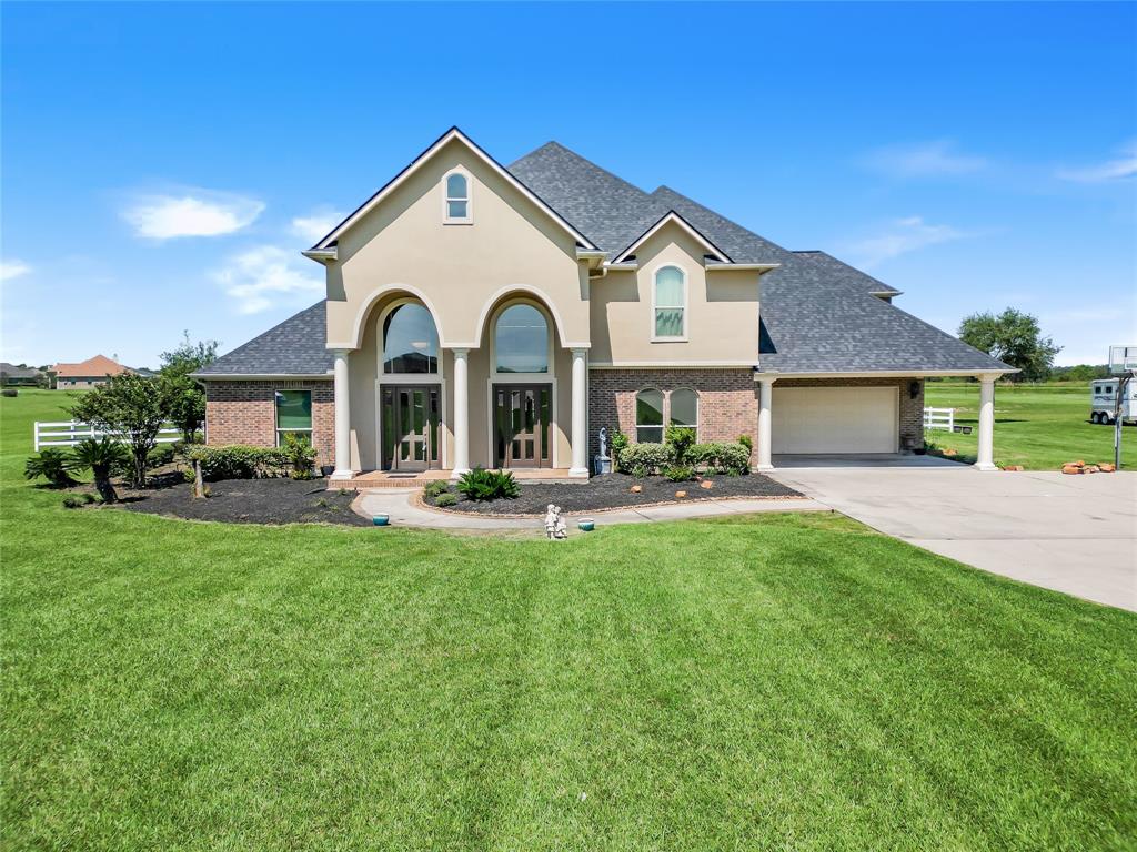 a front view of a house with yard and green space