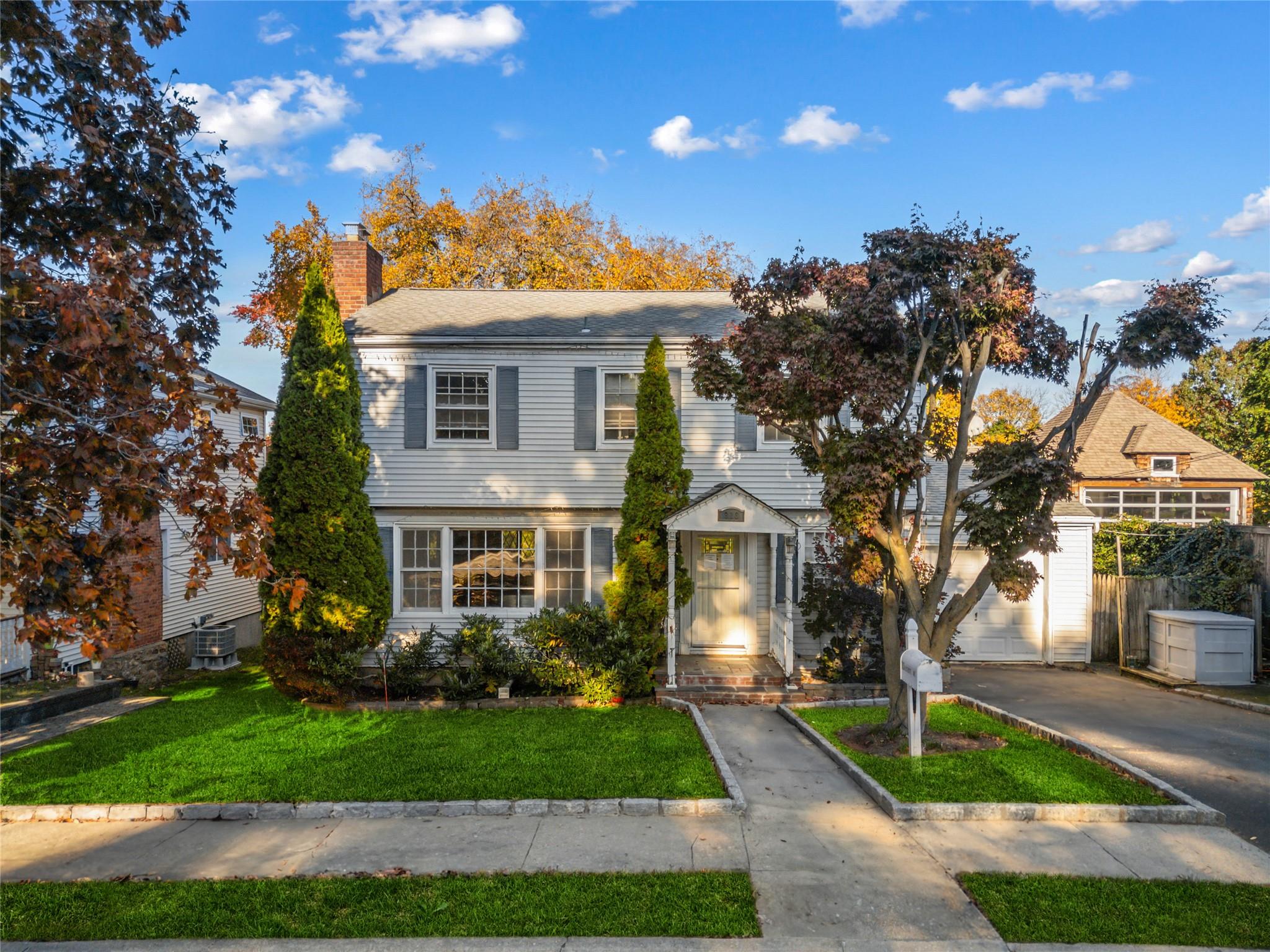 View of front of property with a garage and a front lawn