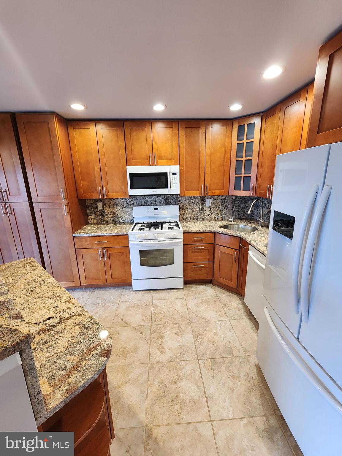 a kitchen with stainless steel appliances granite countertop a stove a sink and a refrigerator