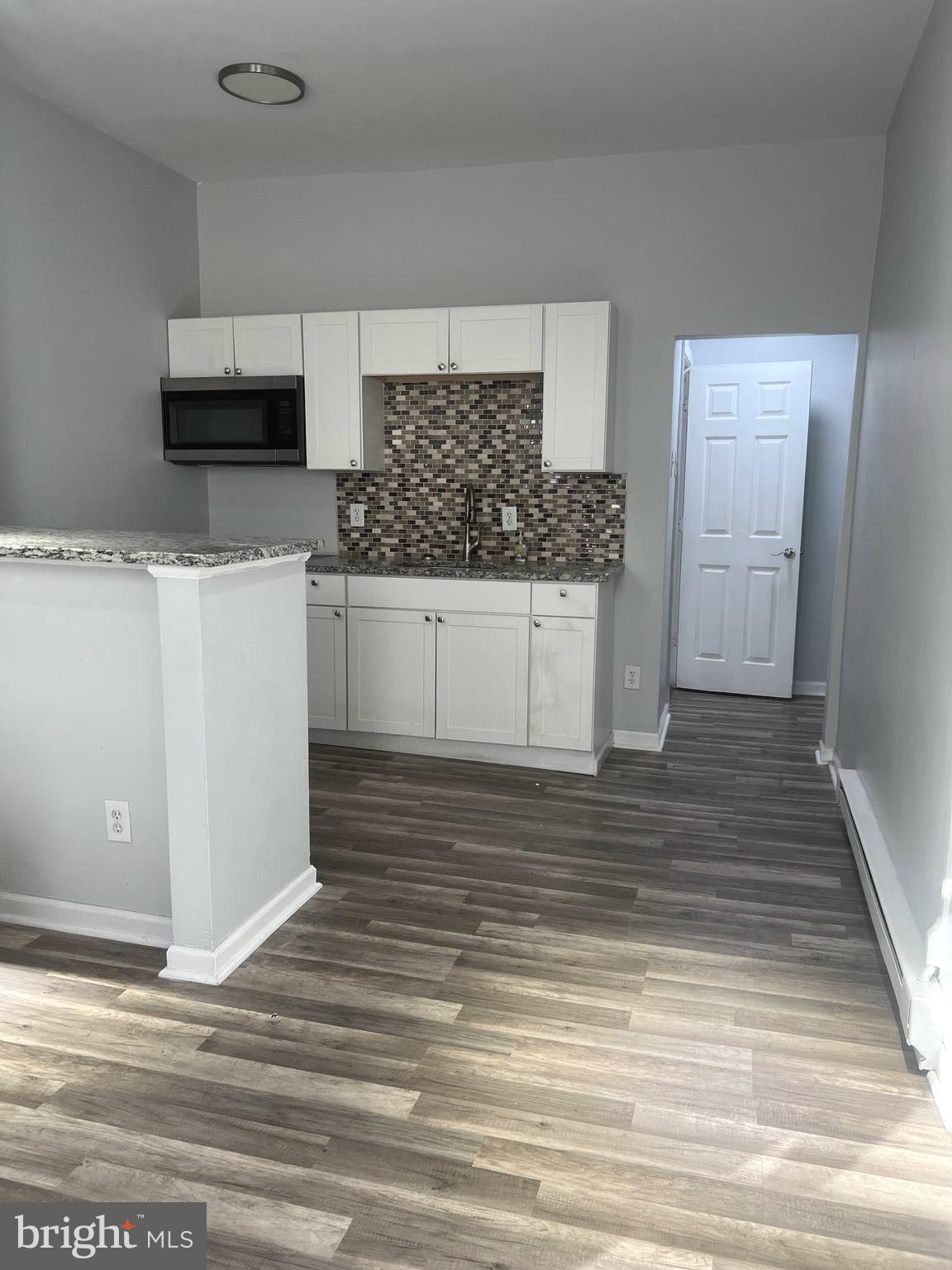 a view of a kitchen with white cabinets