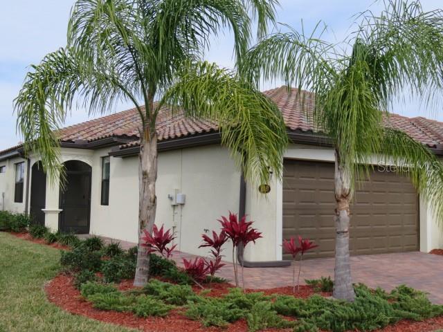 a front view of a house with a tree