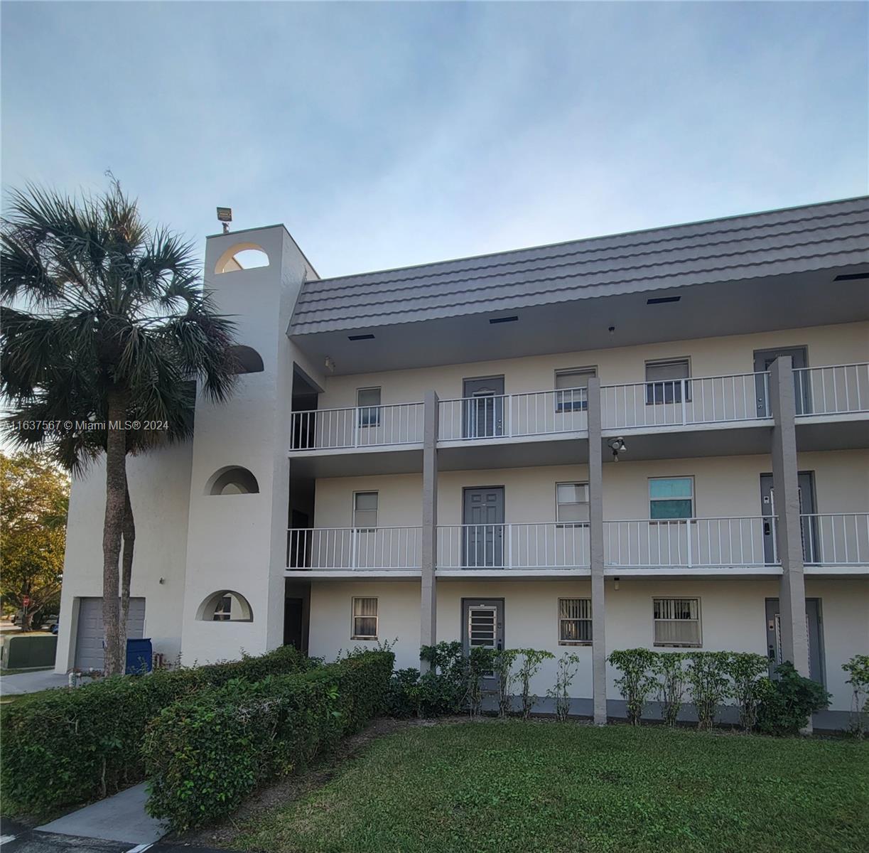 a front view of a building with a garden