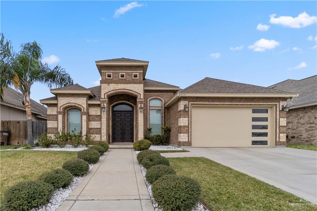 a front view of a house with a yard and garage