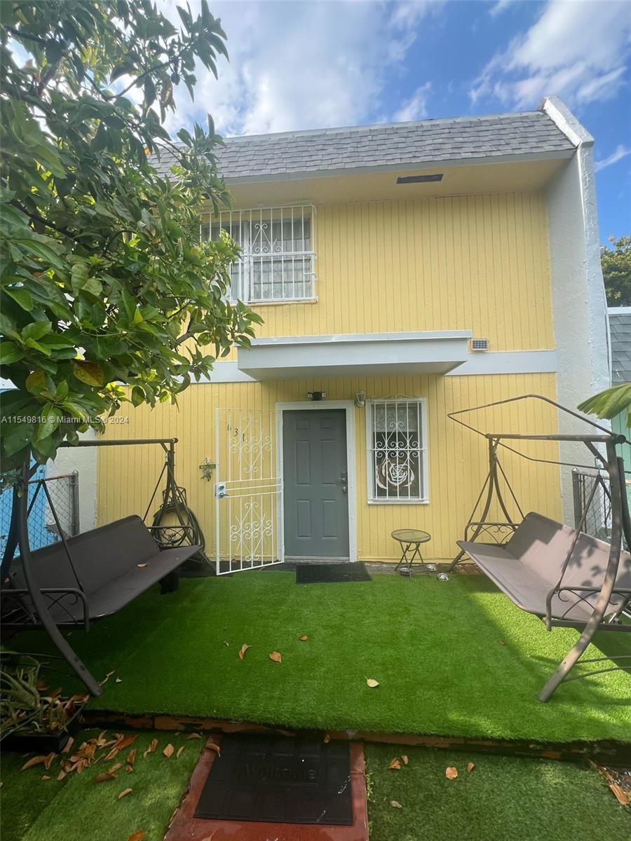 a view of a house with backyard and sitting area