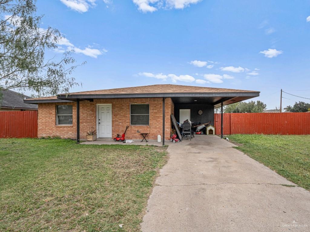 View of front of property featuring a front yard and a carport