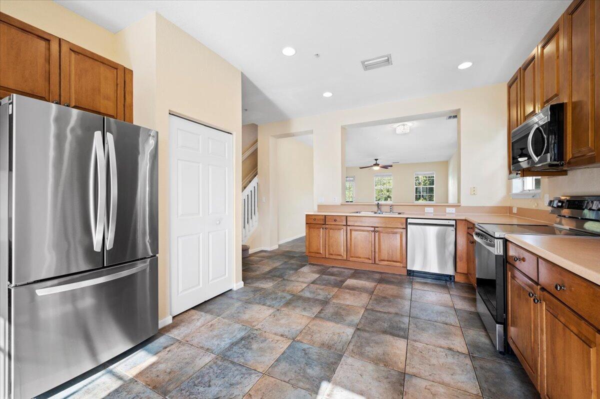 a kitchen with stainless steel appliances a refrigerator sink and microwave