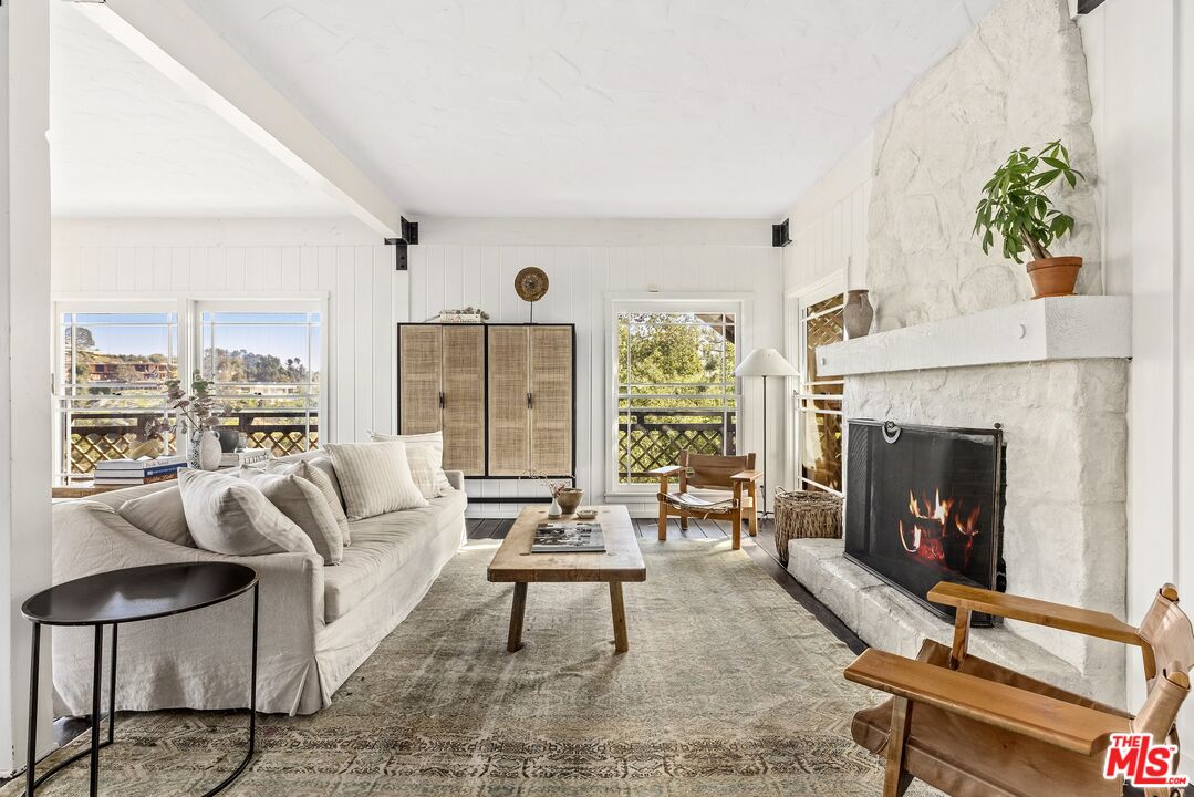 a living room with furniture a fireplace and a floor to ceiling window