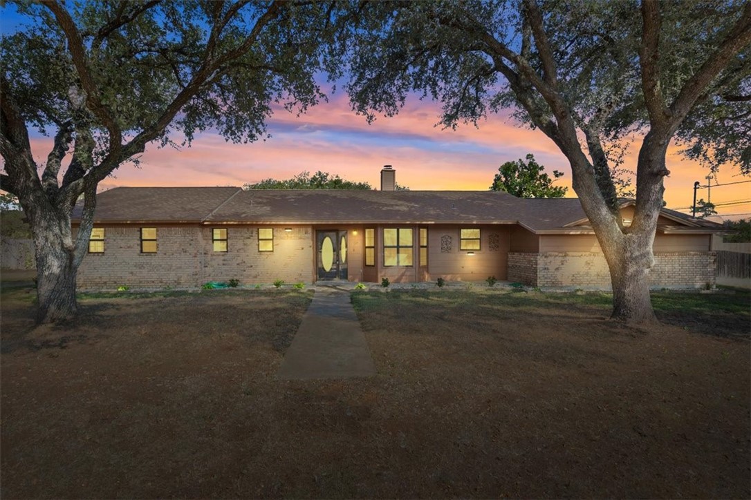 a front view of a house with a yard and lake view