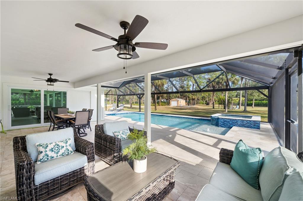 View of swimming pool with outdoor lounge area, a patio, ceiling fan, and a lanai