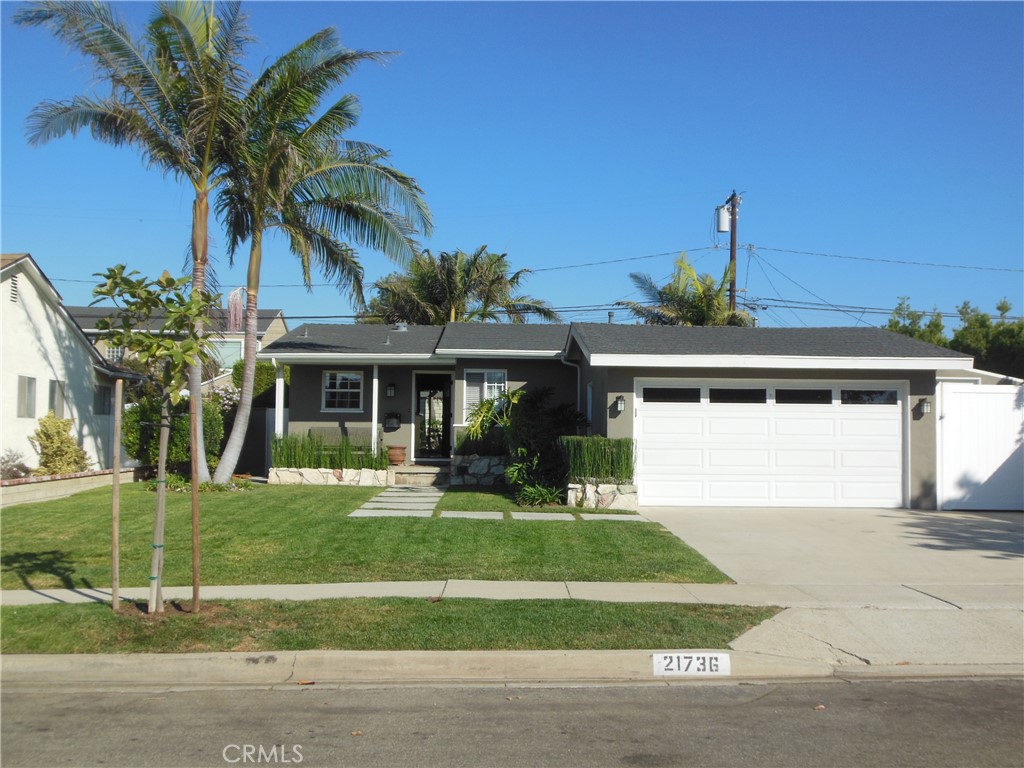 a front view of a house with a yard and potted plants