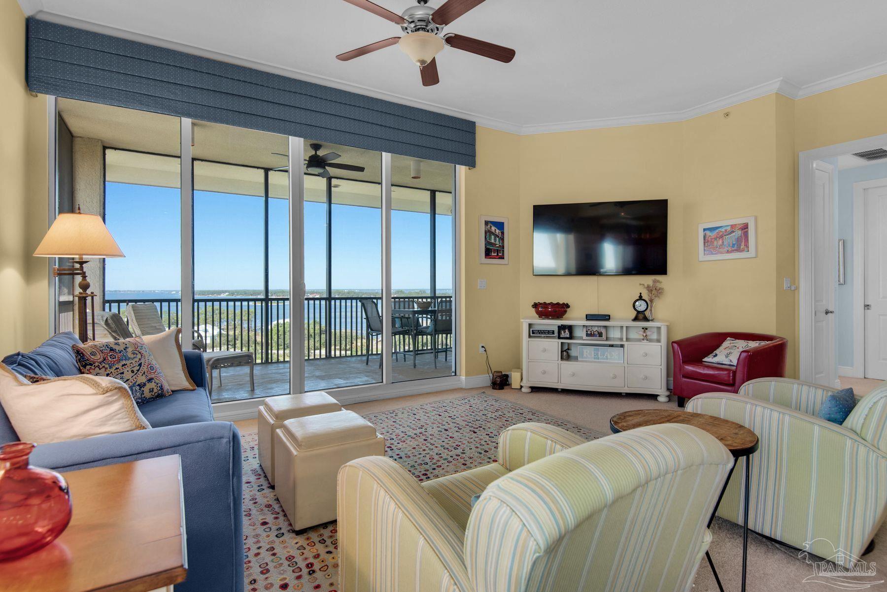 a living room with furniture a flat screen tv and a large window