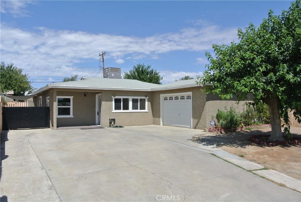 a front view of house with yard and trees in the background