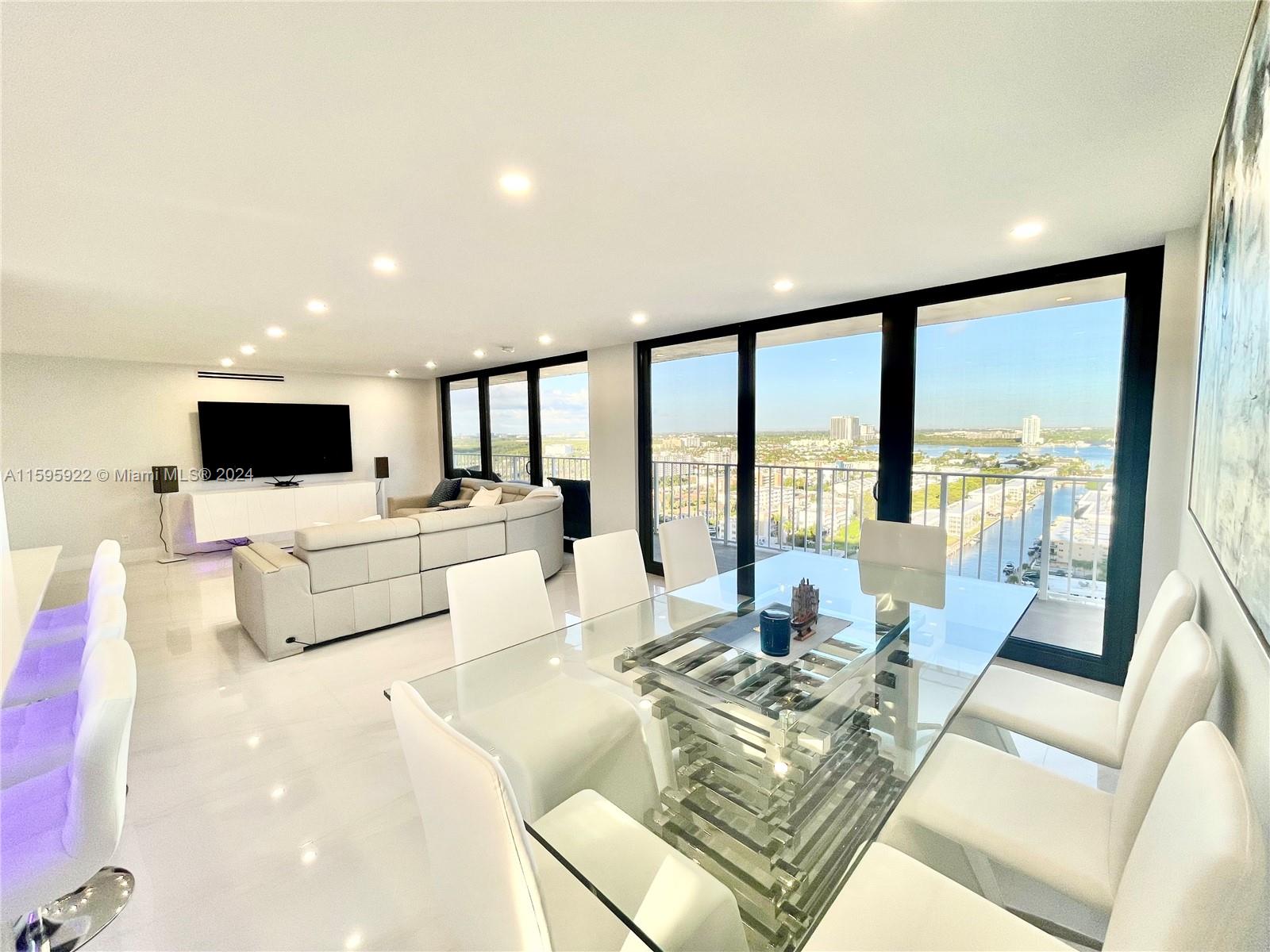 a living room with furniture flat screen tv and a large window