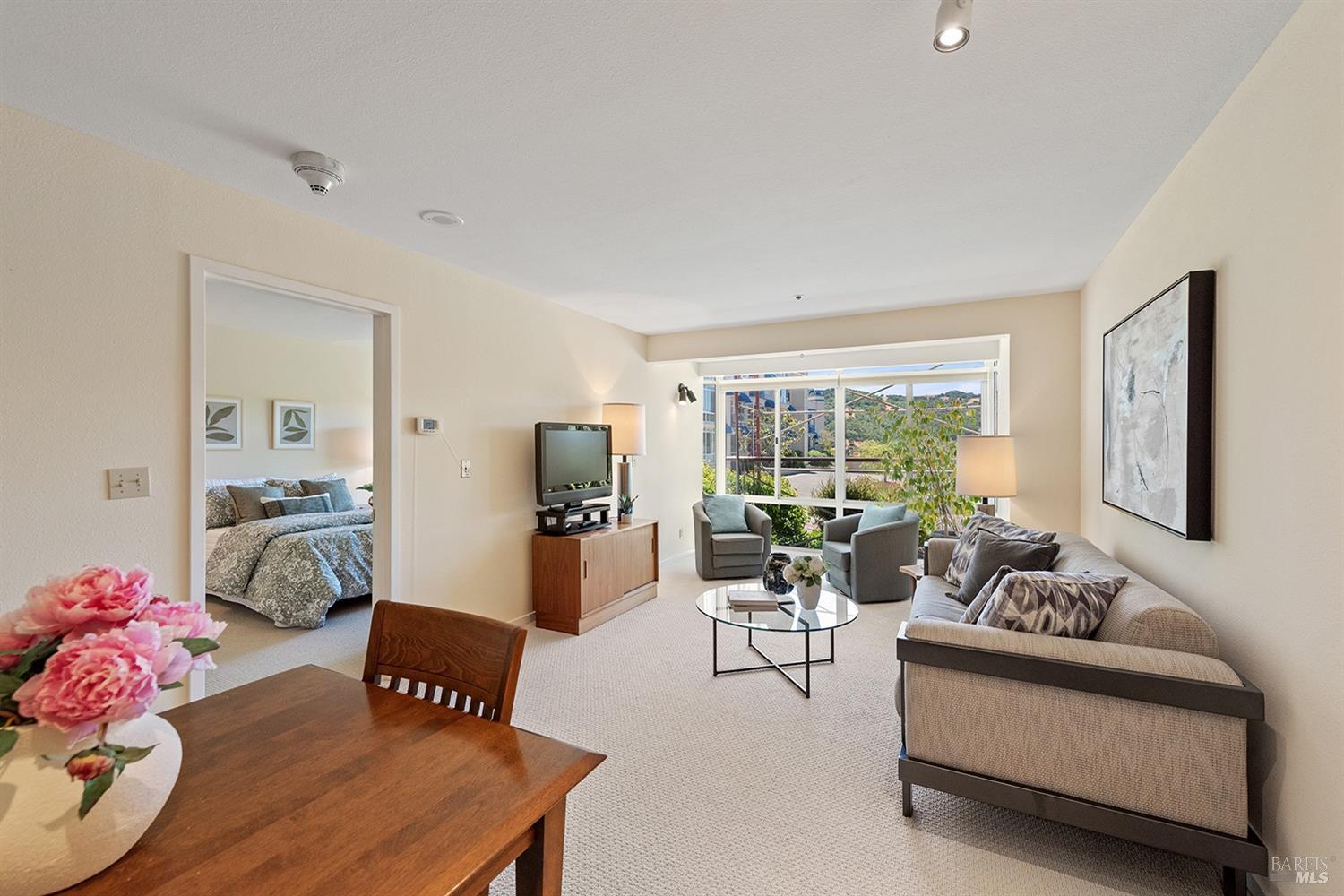 a living room with furniture and floor to ceiling window