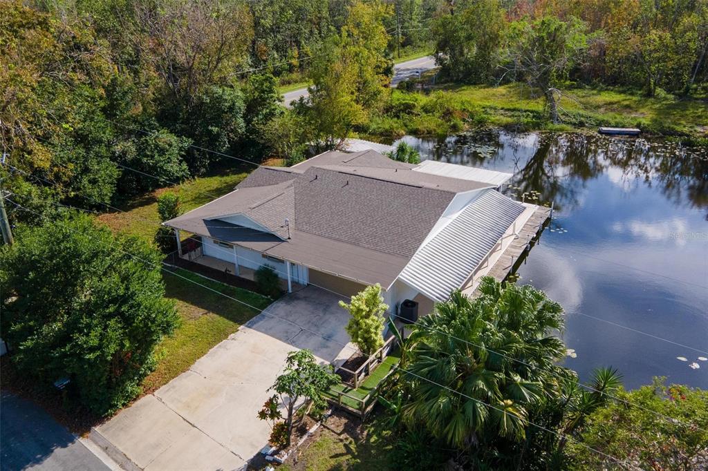 an aerial view of a house with garden space and lake view