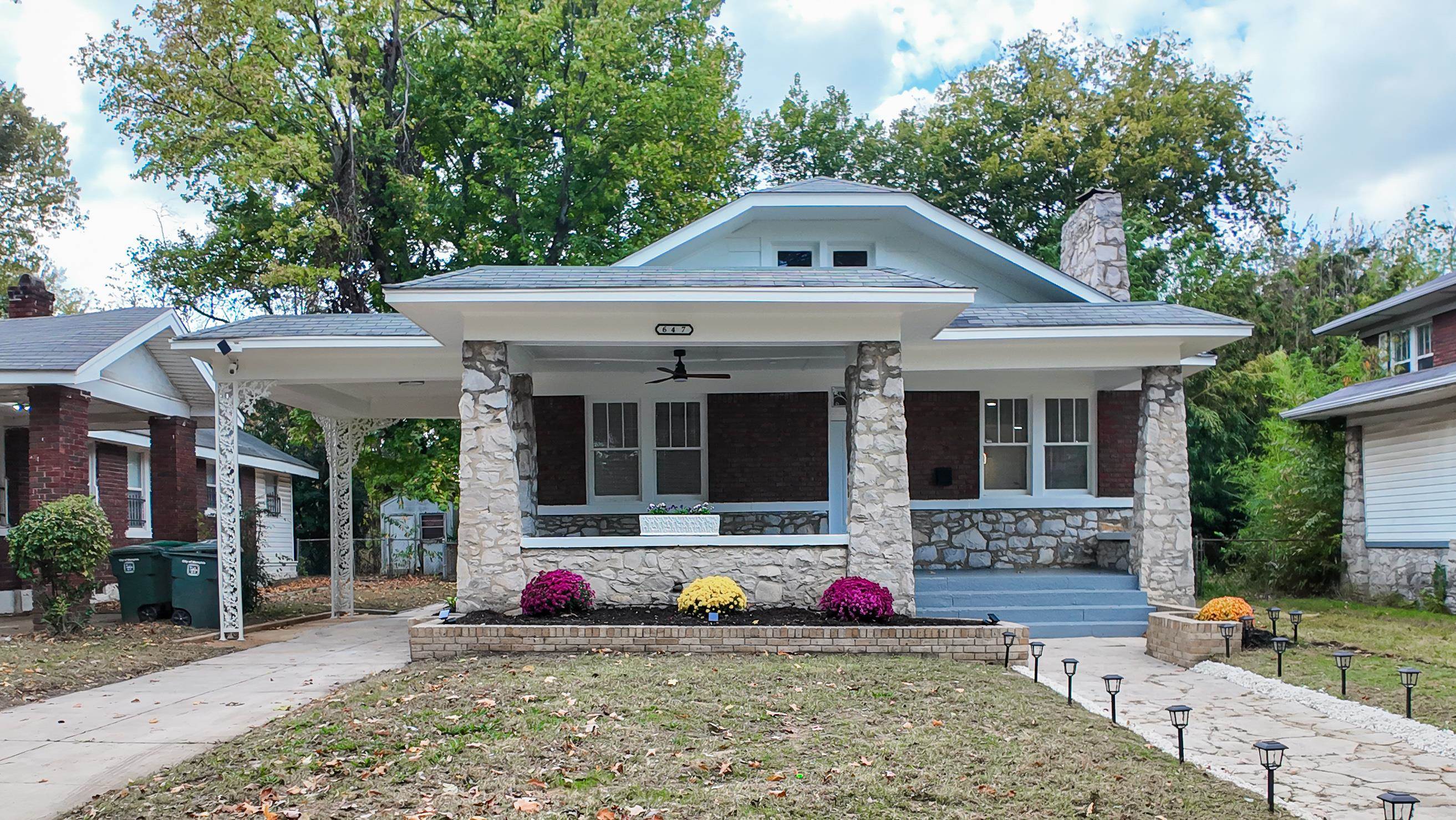 View of front of home with ceiling fan, a front yard, and covered porch