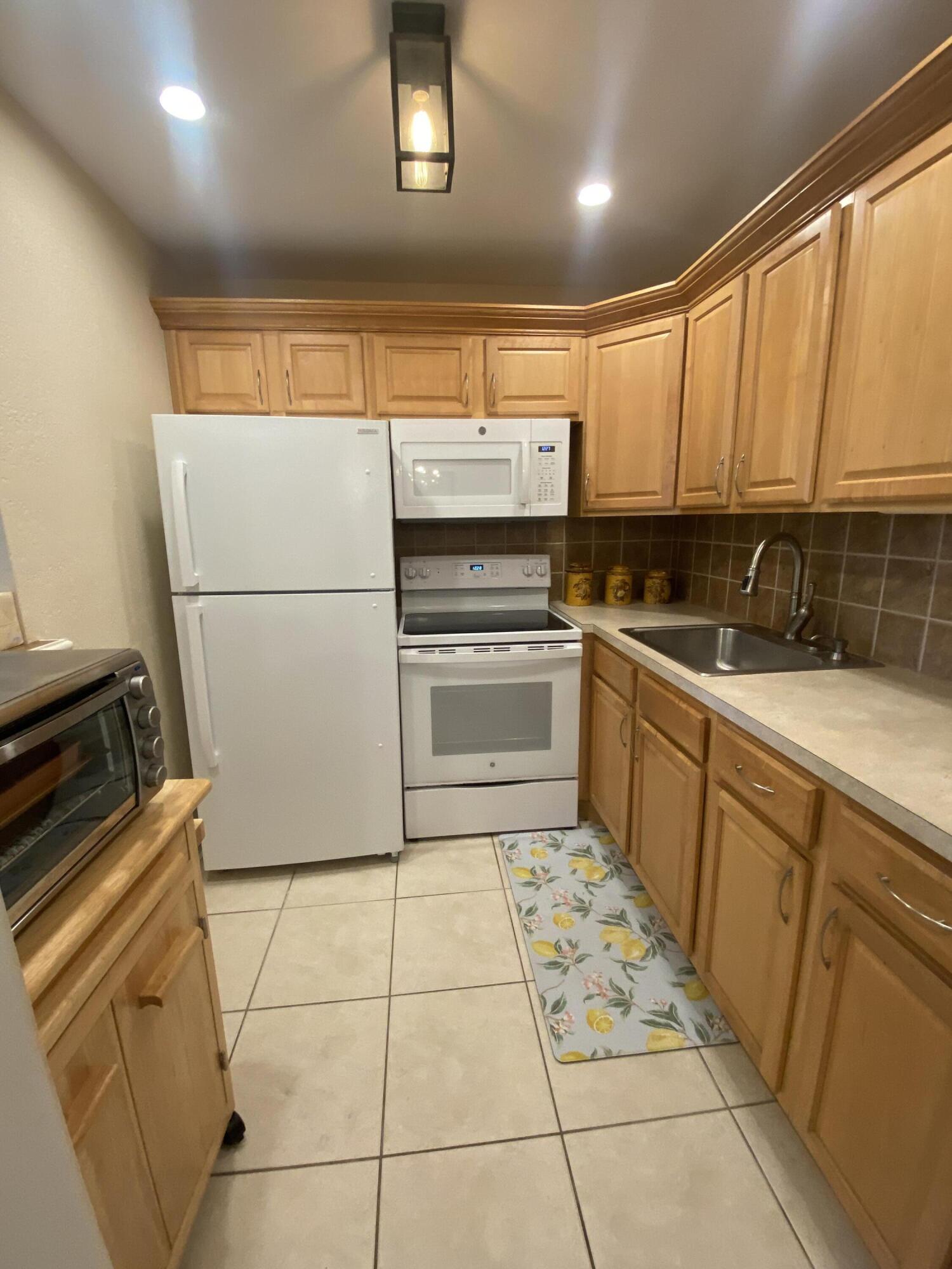 a kitchen with a sink a stove top oven and cabinets