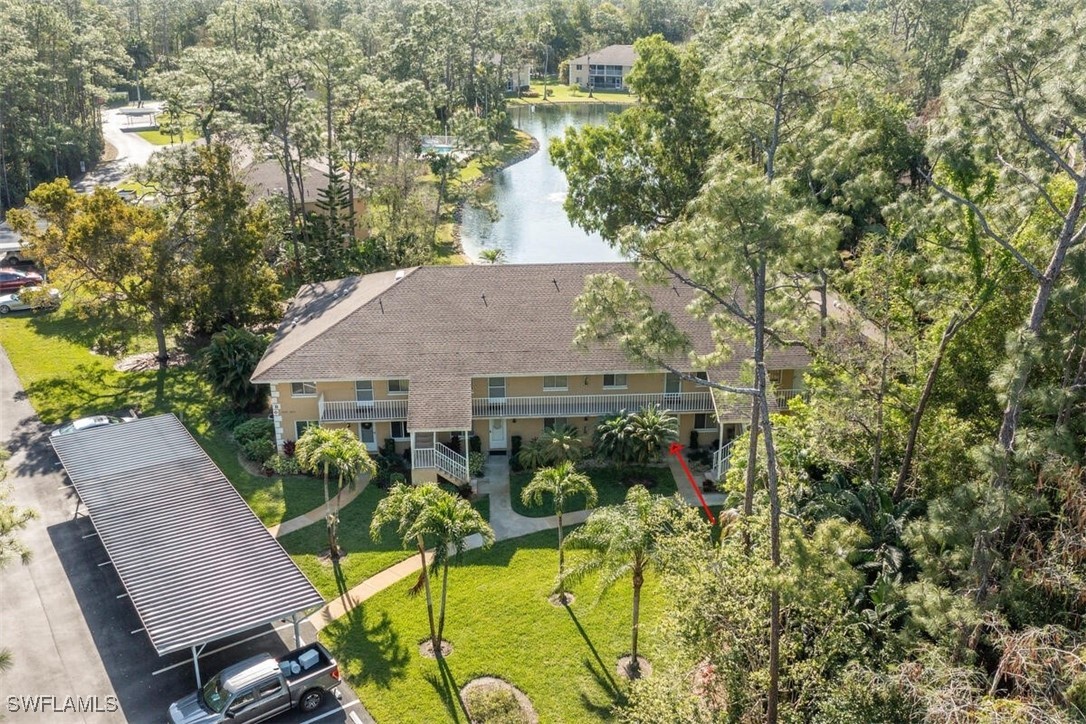 an aerial view of a house with swimming pool and large trees