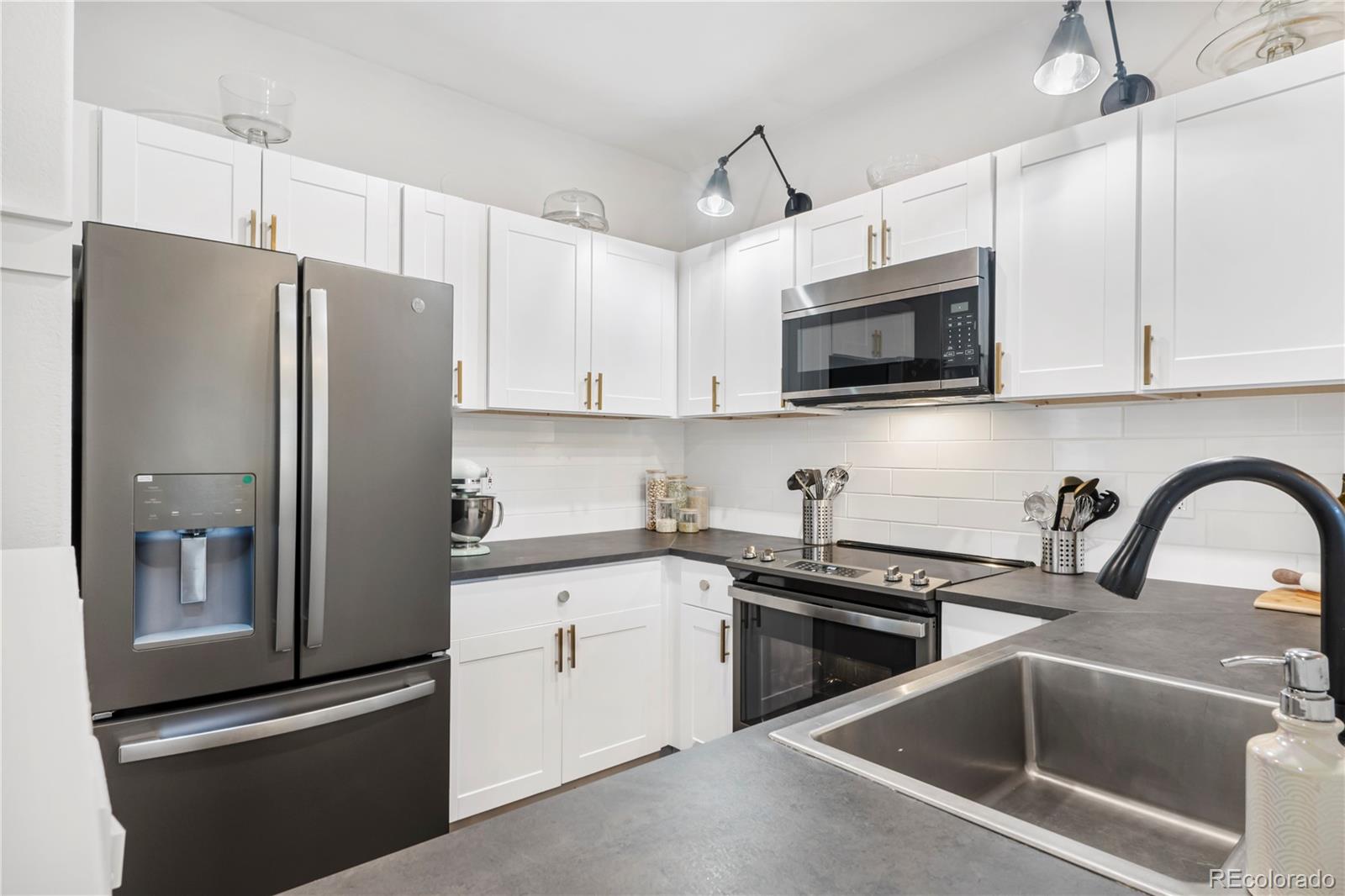 a kitchen with stainless steel appliances a refrigerator sink and microwave