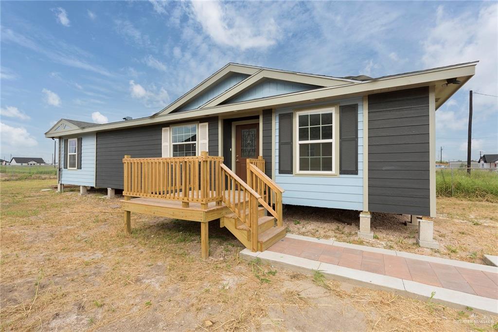 a view of a house with a wooden deck and a yard