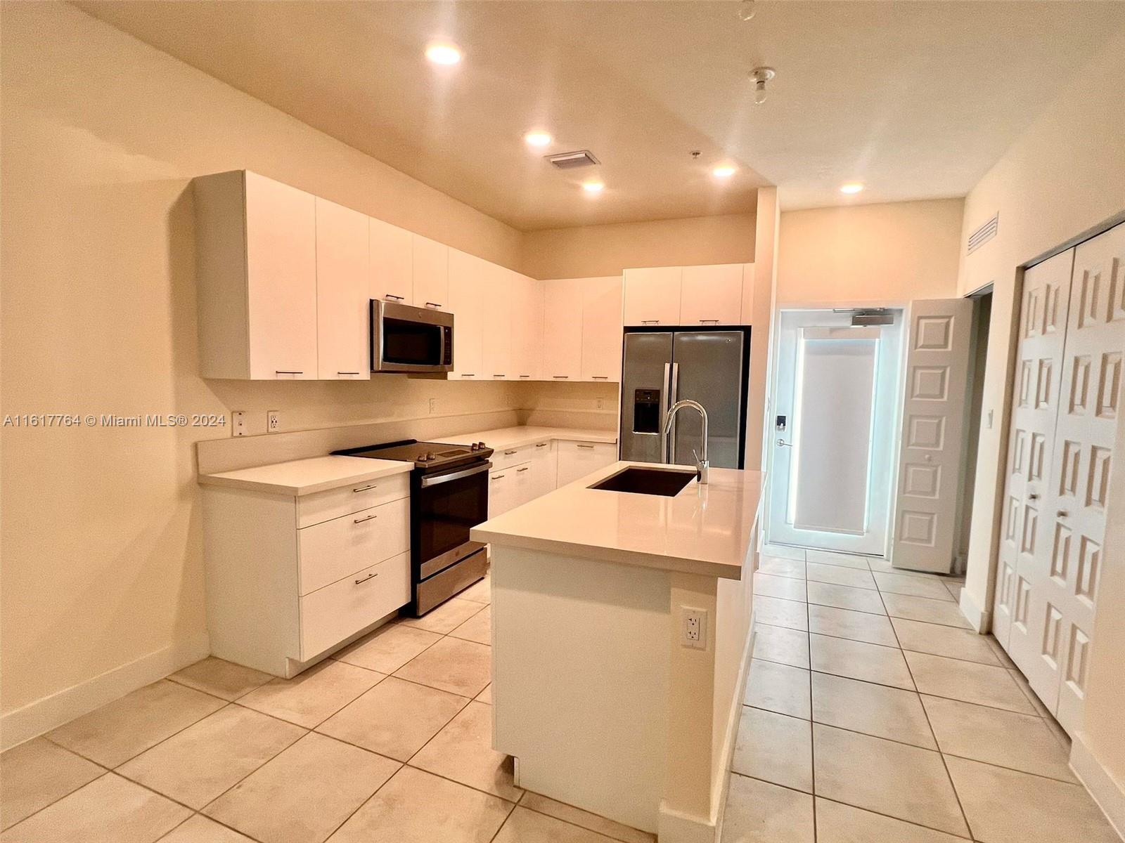 a kitchen with a sink a stove and a refrigerator