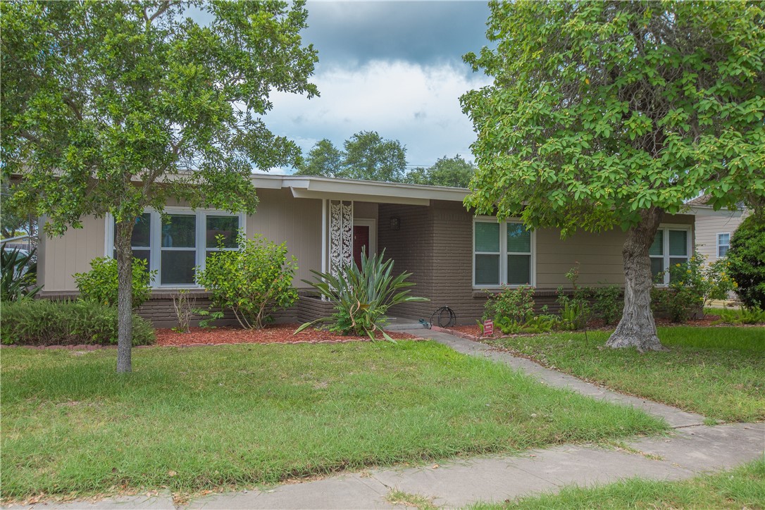 a front view of house with a garden and yard