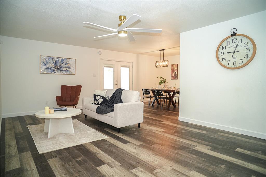 a living room with furniture a clock on wall and a window