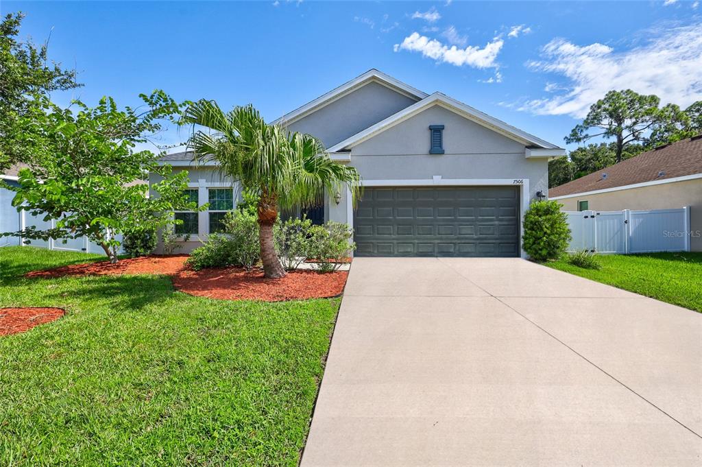 a front view of a house with a yard and garage