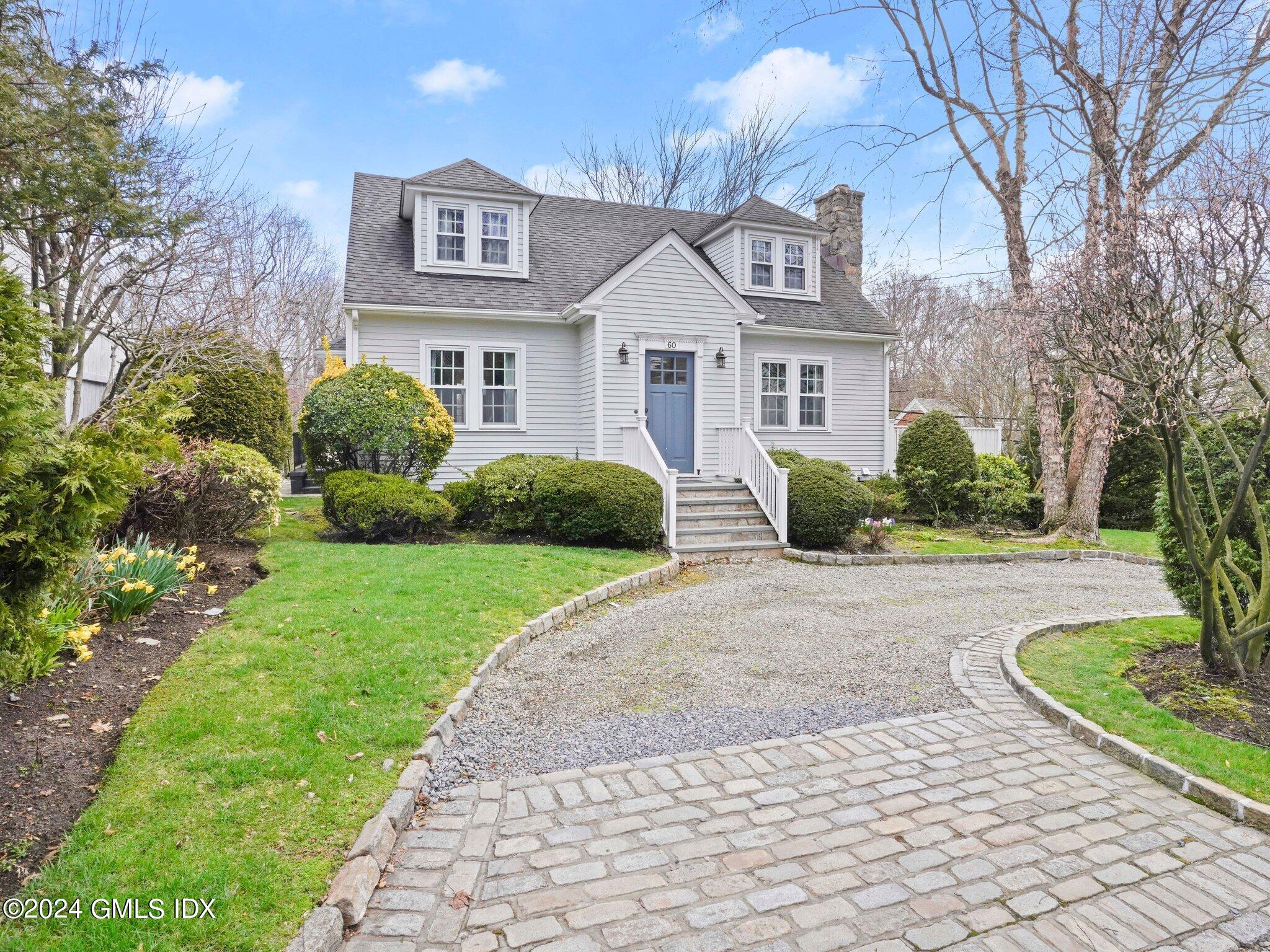 a front view of a house with a yard and trees